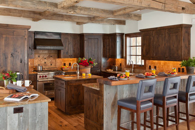 Kitchen - large rustic u-shaped medium tone wood floor and brown floor kitchen idea in Jackson with an undermount sink, shaker cabinets, dark wood cabinets, brown backsplash, stone tile backsplash, stainless steel appliances and an island