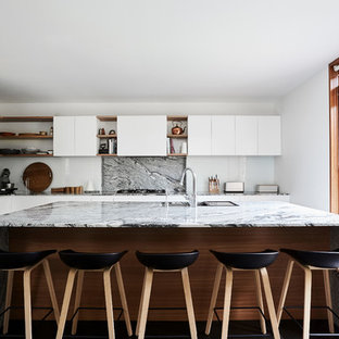Design ideas for a large contemporary l-shaped kitchen in Melbourne with an undermount sink, white cabinets, granite benchtops, multi-coloured splashback, stone slab splashback, stainless steel appliances, with island, black floor, flat-panel cabinets and multi-coloured benchtop.