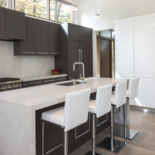 Diseño de cocina moderna con fregadero bajoencimera, armarios con paneles lisos, salpicadero beige, electrodomésticos de acero inoxidable, una isla, puertas de armario de madera en tonos medios, salpicadero de losas de piedra, suelo de baldosas de porcelana y suelo marrón