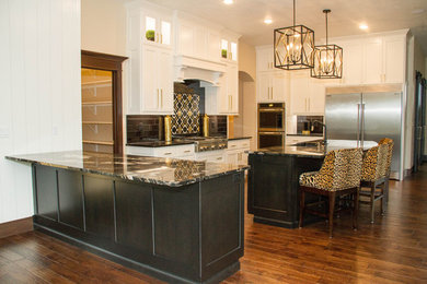 Example of a minimalist medium tone wood floor eat-in kitchen design in Other with flat-panel cabinets, black cabinets, granite countertops, black backsplash and two islands