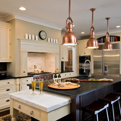 Kitchen - traditional kitchen idea in New York with beaded inset cabinets, stainless steel appliances, soapstone countertops, beige cabinets, white backsplash and stone tile backsplash