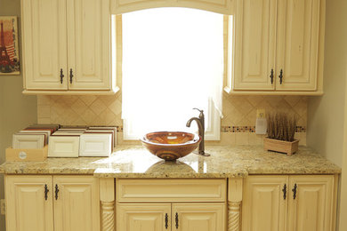 Elegant kitchen photo in New York with a single-bowl sink, distressed cabinets, granite countertops, beige backsplash and stone tile backsplash