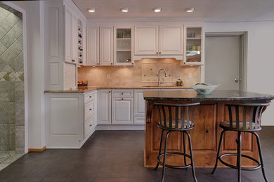 Mid-sized elegant l-shaped ceramic tile eat-in kitchen photo in DC Metro with a double-bowl sink, white cabinets, granite countertops, beige backsplash, ceramic backsplash, stainless steel appliances, an island and raised-panel cabinets