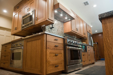 Exempel på ett stort amerikanskt kök, med en undermonterad diskho, skåp i shakerstil, skåp i mellenmörkt trä, granitbänkskiva, flerfärgad stänkskydd, rostfria vitvaror, en köksö, stänkskydd i mosaik och klinkergolv i porslin