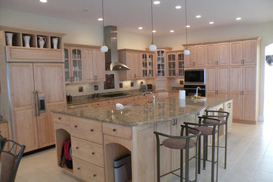 Elegant l-shaped eat-in kitchen photo in Boston with an undermount sink, raised-panel cabinets, light wood cabinets, marble countertops, beige backsplash, stone slab backsplash and stainless steel appliances