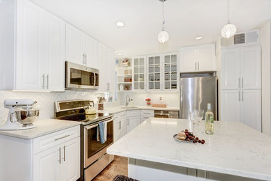 Eat-in kitchen - mid-sized contemporary l-shaped medium tone wood floor eat-in kitchen idea in DC Metro with an undermount sink, shaker cabinets, white cabinets, quartz countertops, white backsplash, porcelain backsplash, stainless steel appliances and an island