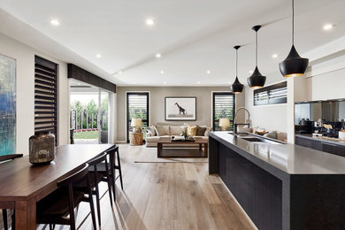 Idéer för ett stort modernt grå linjärt kök med öppen planlösning, med en dubbel diskho, rostfria vitvaror, ljust trägolv, en köksö och brunt golv
