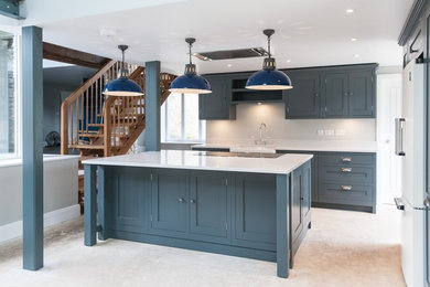 Photo of a large traditional l-shaped open plan kitchen in Gloucestershire with a built-in sink, shaker cabinets, blue cabinets, marble worktops, white splashback, marble splashback, stainless steel appliances, limestone flooring, an island and grey floors.