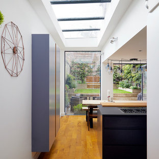 Idee per una grande cucina design con lavello integrato, ante lisce, ante viola, top in superficie solida, paraspruzzi bianco, paraspruzzi in lastra di pietra, elettrodomestici in acciaio inossidabile, pavimento in legno massello medio e pavimento marrone