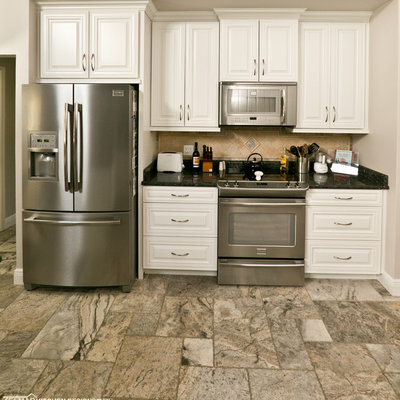 Eat-in kitchen - mid-sized transitional u-shaped travertine floor eat-in kitchen idea in Orlando with raised-panel cabinets, granite countertops, beige backsplash, stone tile backsplash and a peninsula