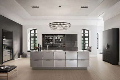 Стильный дизайн: кухня-гостиная в современном стиле с фасадами из нержавеющей стали, светлым паркетным полом, островом и коричневым полом - последний тренд