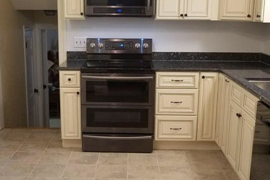 Cette image montre une cuisine avec un évier 1 bac, des portes de placard blanches et un plan de travail en granite.