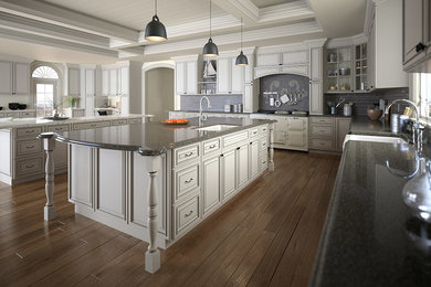 Large elegant u-shaped medium tone wood floor kitchen pantry photo in New York with a farmhouse sink, raised-panel cabinets, white cabinets, granite countertops, gray backsplash, stainless steel appliances and an island