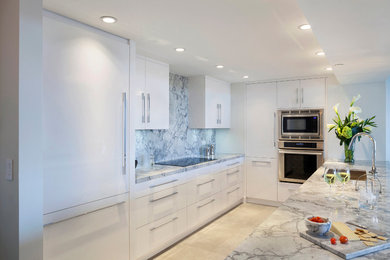 This is an example of a medium sized contemporary u-shaped open plan kitchen in Miami with flat-panel cabinets, white cabinets, marble worktops, grey splashback, stone slab splashback, stainless steel appliances, an island, a submerged sink, travertine flooring, beige floors and grey worktops.