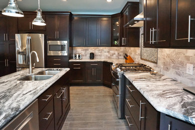 Example of a large transitional l-shaped vinyl floor and brown floor eat-in kitchen design in Philadelphia with a double-bowl sink, granite countertops, gray backsplash, stone tile backsplash, stainless steel appliances, an island, shaker cabinets and dark wood cabinets