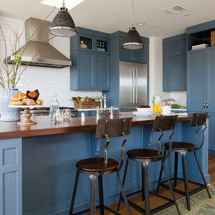 Transitional kitchen designs - Inspiration for a transitional medium tone wood floor kitchen remodel in Los Angeles with shaker cabinets, blue cabinets, wood countertops, white backsplash, ceramic backsplash, stainless steel appliances and an island