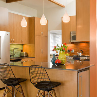 Inspiration for a mid-sized midcentury l-shaped open plan kitchen in Los Angeles with a drop-in sink, flat-panel cabinets, light wood cabinets, orange splashback, stainless steel appliances, light hardwood floors and no island.