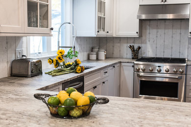 Example of a small transitional u-shaped medium tone wood floor kitchen design in New York with a single-bowl sink, shaker cabinets, gray cabinets, granite countertops, white backsplash, stone tile backsplash, stainless steel appliances and a peninsula