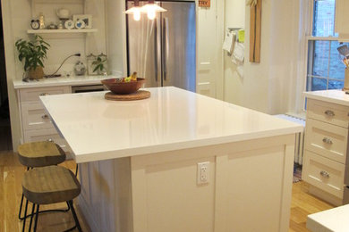 Example of a classic l-shaped light wood floor eat-in kitchen design in Toronto with an undermount sink, shaker cabinets, white cabinets, granite countertops, white backsplash, subway tile backsplash, stainless steel appliances and an island