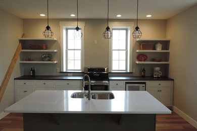 Example of a mid-sized mountain style single-wall light wood floor eat-in kitchen design in Other with a double-bowl sink, shaker cabinets, white cabinets, stainless steel appliances, an island and quartz countertops