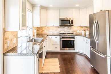 Mittelgroße Rustikale Küche mit Waschbecken, Granit-Arbeitsplatte, Küchengeräten aus Edelstahl und braunem Holzboden in Orange County