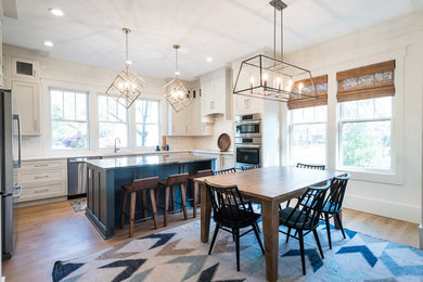 Open concept kitchen - mid-sized modern u-shaped light wood floor and brown floor open concept kitchen idea in Charleston with an undermount sink, shaker cabinets, white cabinets, quartz countertops, white backsplash, stainless steel appliances and an island