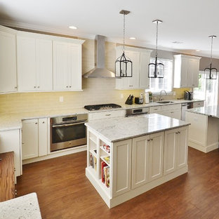 Large transitional open concept kitchen photos - Large transitional galley medium tone wood floor open concept kitchen photo in Philadelphia with an undermount sink, white cabinets, granite countertops, beige backsplash, subway tile backsplash, stainless steel appliances, two islands and shaker cabinets