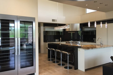 Mid-sized minimalist u-shaped ceramic tile and beige floor open concept kitchen photo in Phoenix with an undermount sink, flat-panel cabinets, white cabinets, granite countertops, black backsplash, stone slab backsplash, stainless steel appliances and an island