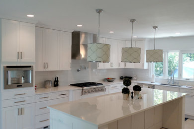 Inspiration for a large modern l-shaped white floor enclosed kitchen remodel in DC Metro with an undermount sink, shaker cabinets, white cabinets, quartz countertops, white backsplash, subway tile backsplash, stainless steel appliances and an island