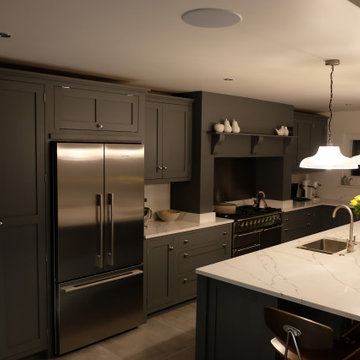 Sleek dark grey hand painted kitchen with tall larder, and glazed units
