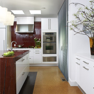 Immagine di una cucina minimalista di medie dimensioni con elettrodomestici in acciaio inossidabile, pavimento arancione, lavello da incasso, ante lisce, ante bianche, top in granito, paraspruzzi rosso, paraspruzzi con piastrelle in ceramica, pavimento in sughero e top rosso