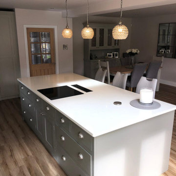 Sleek, light grey handmade kitchen with large island and white worktops