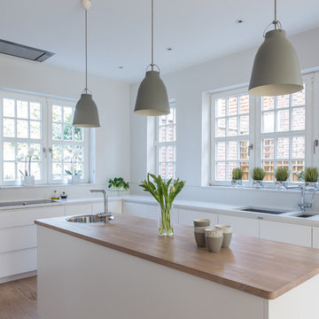 Sleek Scandinavian kitchen in white with separate pantry