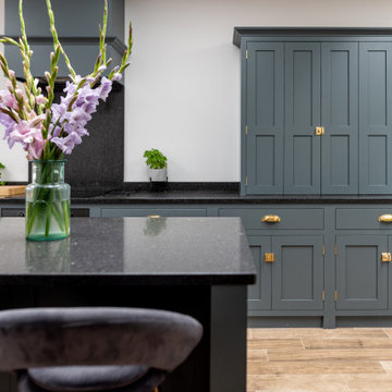 Sleek, stylish and sophisticated dark teal flat panelled kitchen with island