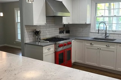 Inspiration for a mid-sized transitional l-shaped medium tone wood floor and brown floor enclosed kitchen remodel in Other with an undermount sink, shaker cabinets, white cabinets, quartz countertops, white backsplash, subway tile backsplash, colored appliances, an island and gray countertops