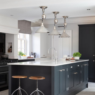 This is an example of a large classic u-shaped kitchen in Other with a submerged sink, shaker cabinets, black cabinets, an island, grey floors and white worktops.