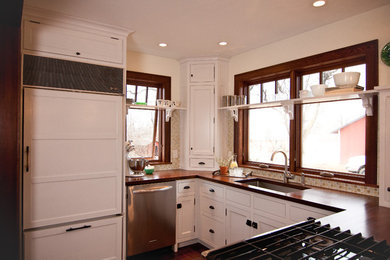 Cottage u-shaped kitchen photo in Minneapolis with wood countertops, paneled appliances, beaded inset cabinets, white cabinets, an undermount sink and mosaic tile backsplash