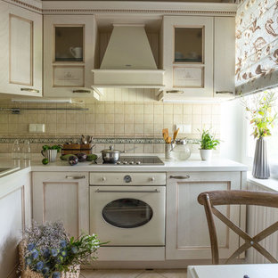 Immagine di una cucina a L tradizionale chiusa con lavello da incasso, ante con riquadro incassato, ante bianche, paraspruzzi beige, elettrodomestici bianchi e nessuna isola