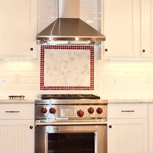 Shabby-chic style u-shaped eat-in kitchen in San Diego with a farmhouse sink, beaded inset cabinets, white cabinets, marble benchtops, red splashback, glass tile splashback, stainless steel appliances, medium hardwood floors and a peninsula.