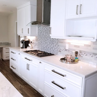 Small traditional enclosed kitchen ideas - Inspiration for a small timeless galley porcelain tile and brown floor enclosed kitchen remodel in Los Angeles with an undermount sink, recessed-panel cabinets, white cabinets, quartz countertops, gray backsplash, glass tile backsplash, stainless steel appliances and no island