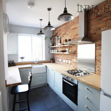 Small Kitchen featuring brick wall and light blue shaker cabinets