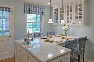 Mid-sized transitional l-shaped light wood floor and brown floor eat-in kitchen photo in Baltimore with recessed-panel cabinets, white cabinets, marble countertops, a peninsula, an undermount sink, white backsplash, mosaic tile backsplash and stainless steel appliances