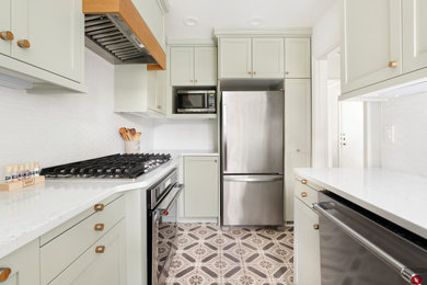 Example of a small transitional cement tile floor and brown floor enclosed kitchen design in Portland with an undermount sink, shaker cabinets, green cabinets, quartz countertops, white backsplash, ceramic backsplash, stainless steel appliances and white countertops