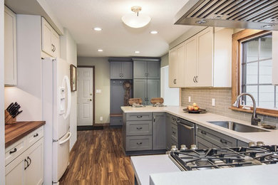 Inspiration for a small transitional galley vinyl floor and brown floor eat-in kitchen remodel in Other with recessed-panel cabinets, white cabinets, gray backsplash and stainless steel appliances