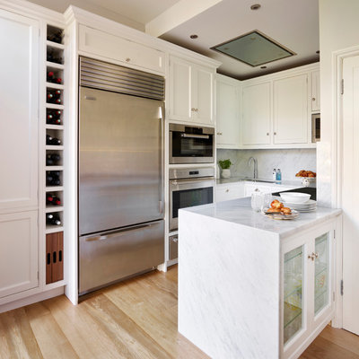 Inspiration for a small transitional u-shaped light wood floor kitchen remodel in Hertfordshire with beaded inset cabinets, white cabinets, white backsplash, stone slab backsplash, stainless steel appliances and a peninsula