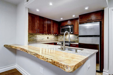 Example of a mid-sized trendy u-shaped beige floor kitchen design in Philadelphia with medium tone wood cabinets, a peninsula, an undermount sink, stainless steel appliances, shaker cabinets, granite countertops, multicolored backsplash, stone tile backsplash and multicolored countertops