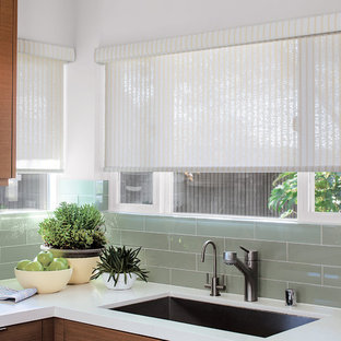 Mid-sized contemporary enclosed kitchen photos - Mid-sized trendy l-shaped enclosed kitchen photo in Los Angeles with a single-bowl sink, glass-front cabinets, brown cabinets, marble countertops, green backsplash, ceramic backsplash, stainless steel appliances and no island