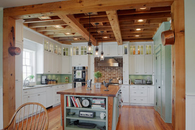 Enclosed kitchen - large coastal u-shaped medium tone wood floor and wood ceiling enclosed kitchen idea in Charleston with an undermount sink, louvered cabinets, white cabinets, granite countertops, stainless steel appliances, an island, multicolored backsplash and stone tile backsplash