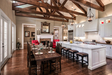 Example of a farmhouse galley open concept kitchen design in Other with an undermount sink, shaker cabinets, white cabinets, white backsplash, subway tile backsplash, stainless steel appliances and an island