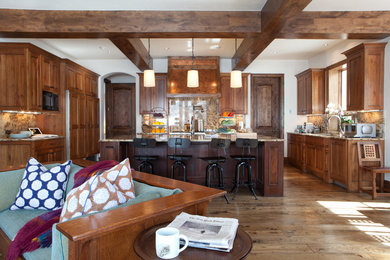 Large transitional galley open concept kitchen photo in Denver with an island, raised-panel cabinets, medium tone wood cabinets, multicolored backsplash and paneled appliances